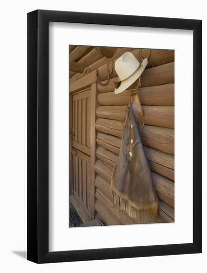 USA, Montana, Livingston, cowboy hat and chaps hanging on barn wall.-Merrill Images-Framed Photographic Print