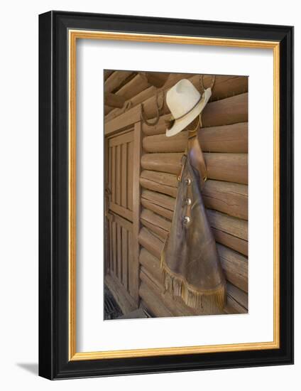 USA, Montana, Livingston, cowboy hat and chaps hanging on barn wall.-Merrill Images-Framed Photographic Print