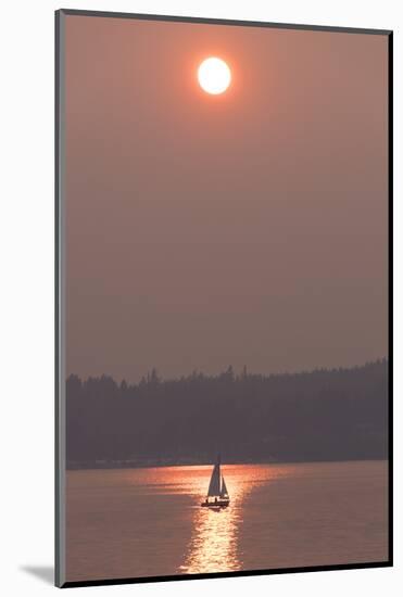 USA, Washington State. Two people in sailboat. Smoky skies from wildfires create eerie sunset-Trish Drury-Mounted Photographic Print