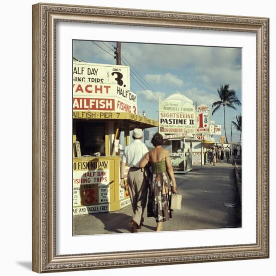 Vacationers Walking by Booths Advertising Boat Tours-Hank Walker-Framed Photographic Print