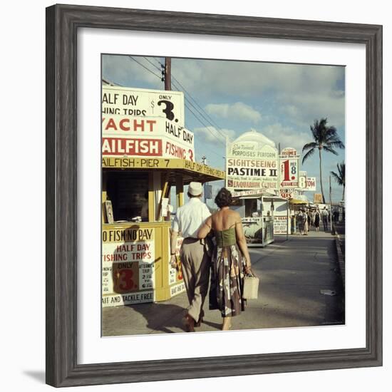 Vacationers Walking by Booths Advertising Boat Tours-Hank Walker-Framed Photographic Print