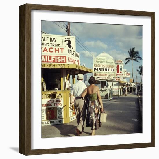 Vacationers Walking by Booths Advertising Boat Tours-Hank Walker-Framed Photographic Print