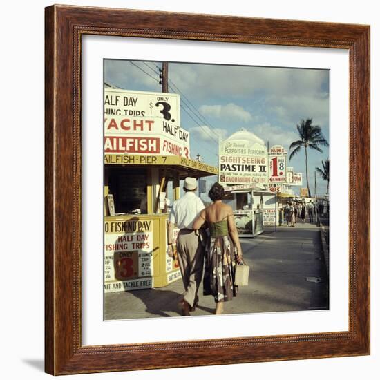 Vacationers Walking by Booths Advertising Boat Tours-Hank Walker-Framed Photographic Print