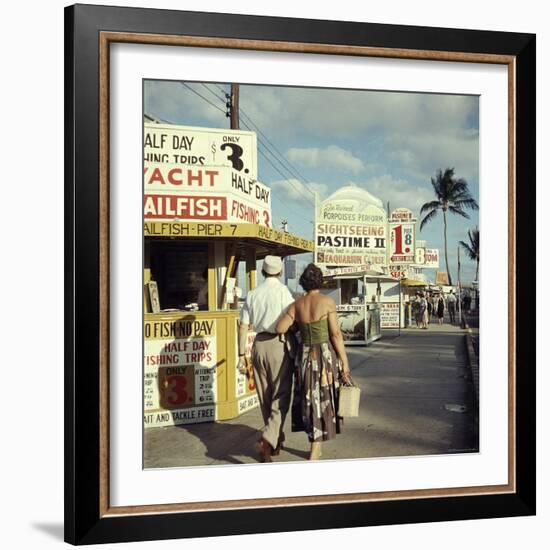 Vacationers Walking by Booths Advertising Boat Tours-Hank Walker-Framed Photographic Print