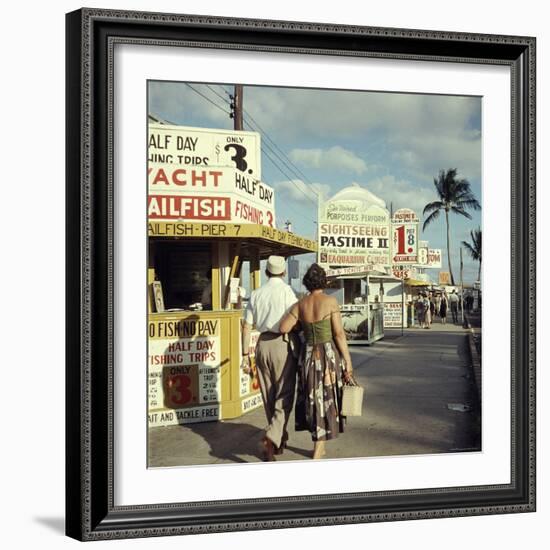 Vacationers Walking by Booths Advertising Boat Tours-Hank Walker-Framed Photographic Print