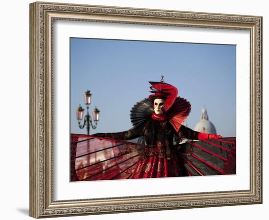 Venice, Veneto, Italy, a Mask in Costume on the Bacino Di San Marco with the Cupola of Santa Maria -Ken Scicluna-Framed Photographic Print