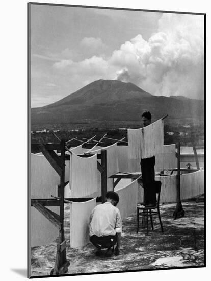 View of Mount Vesuvius from the Town of Torre Annunciata with Men Tending to Drying Pasta-Alfred Eisenstaedt-Mounted Photographic Print