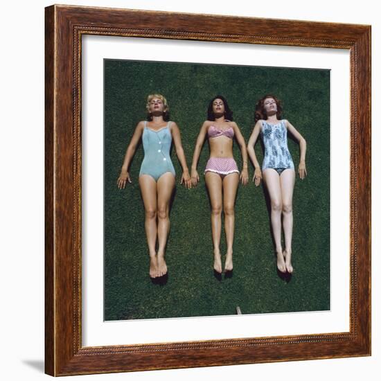 View of Three Unidentified Women in Bathing Suits as They Sunbath on Green Grass, 1961-Allan Grant-Framed Photographic Print