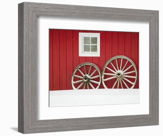 Wagon Wheels on Snow Against Stable-Stuart Westmorland-Framed Photographic Print