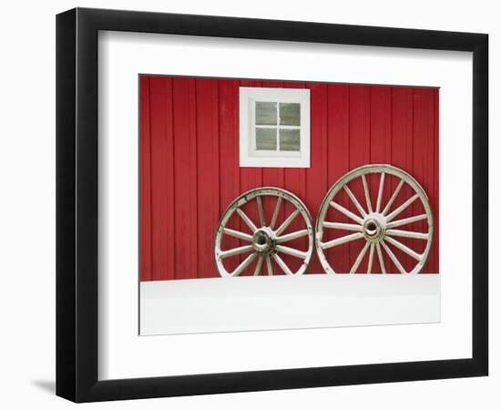 Wagon Wheels on Snow Against Stable-Stuart Westmorland-Framed Photographic Print