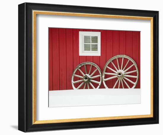 Wagon Wheels on Snow Against Stable-Stuart Westmorland-Framed Photographic Print