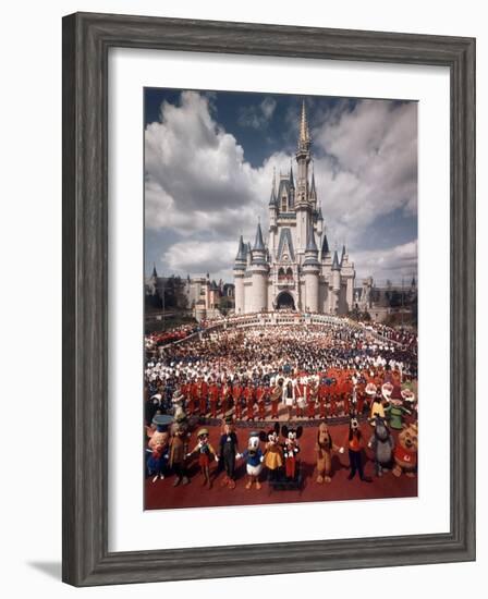 Walt Disney Characters and Park Staff Posing En Masse in Front of Cinderella's Castle-Yale Joel-Framed Photographic Print