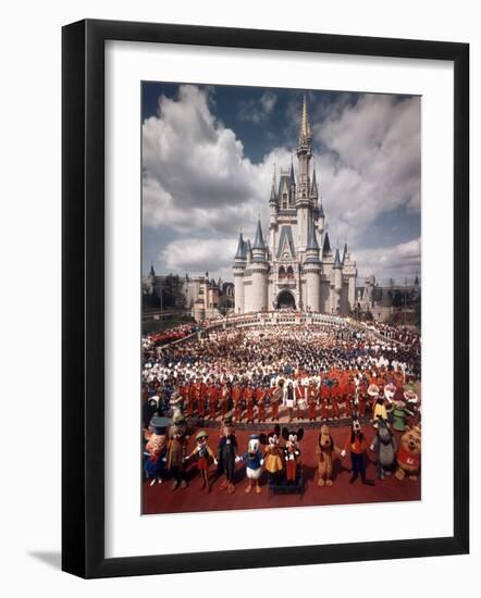 Walt Disney Characters and Park Staff Posing En Masse in Front of Cinderella's Castle-Yale Joel-Framed Photographic Print