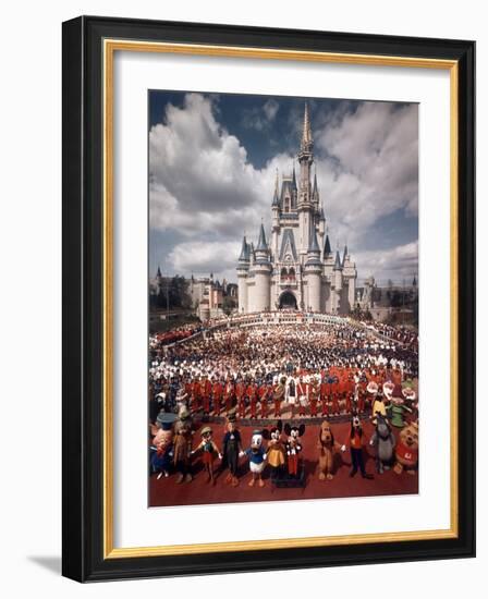 Walt Disney Characters and Park Staff Posing En Masse in Front of Cinderella's Castle-Yale Joel-Framed Photographic Print