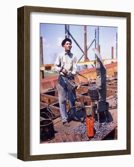 War Worker Holding Red Hot Metal Piece with Tongs at Shipyard-George Strock-Framed Photographic Print