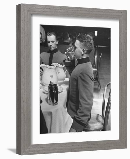 West Point Cadet Drinking a Glass of Water as He Sits at Attention in Mess Hall at the Academy-Alfred Eisenstaedt-Framed Photographic Print