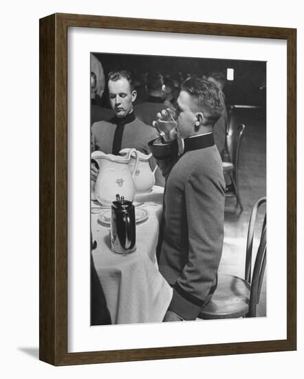 West Point Cadet Drinking a Glass of Water as He Sits at Attention in Mess Hall at the Academy-Alfred Eisenstaedt-Framed Photographic Print