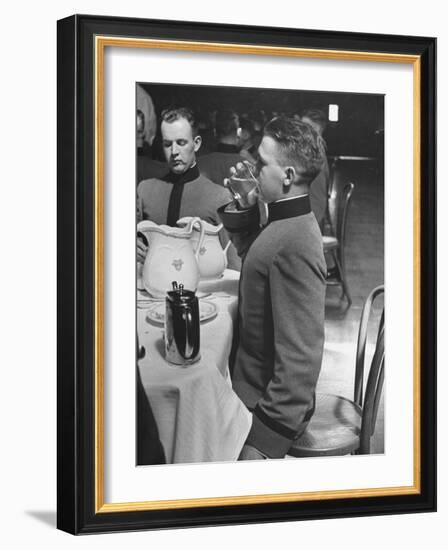 West Point Cadet Drinking a Glass of Water as He Sits at Attention in Mess Hall at the Academy-Alfred Eisenstaedt-Framed Photographic Print