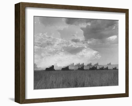 Wheat Harvest Time with Two Lines of Combines Lining Up in Field with Threatening Sky-Joe Scherschel-Framed Photographic Print