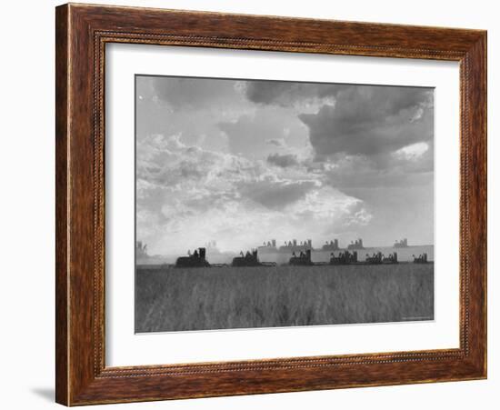 Wheat Harvest Time with Two Lines of Combines Lining Up in Field with Threatening Sky-Joe Scherschel-Framed Photographic Print