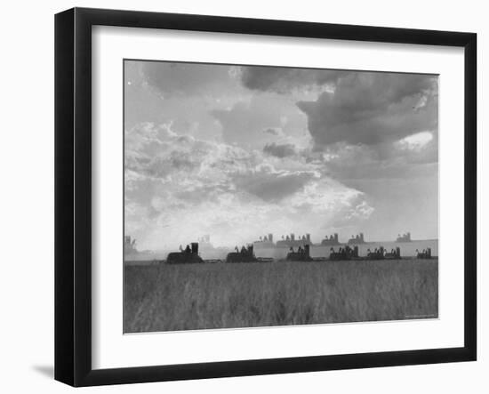 Wheat Harvest Time with Two Lines of Combines Lining Up in Field with Threatening Sky-Joe Scherschel-Framed Photographic Print