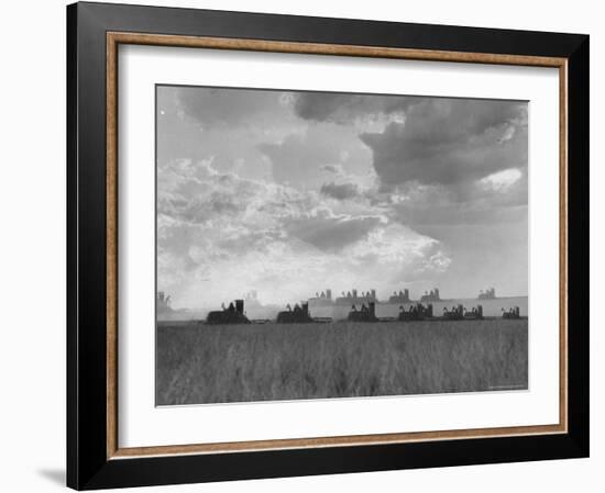 Wheat Harvest Time with Two Lines of Combines Lining Up in Field with Threatening Sky-Joe Scherschel-Framed Photographic Print