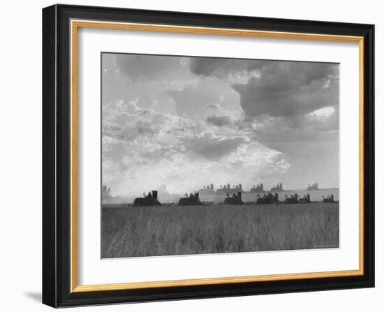 Wheat Harvest Time with Two Lines of Combines Lining Up in Field with Threatening Sky-Joe Scherschel-Framed Photographic Print