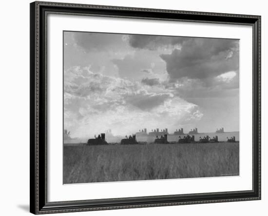 Wheat Harvest Time with Two Lines of Combines Lining Up in Field with Threatening Sky-Joe Scherschel-Framed Photographic Print