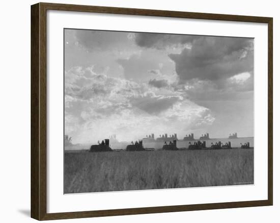 Wheat Harvest Time with Two Lines of Combines Lining Up in Field with Threatening Sky-Joe Scherschel-Framed Photographic Print