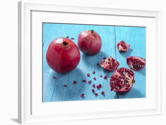 Whole and Cut Pomegranates on Turquoise Wooden Table-Jana Ihle-Framed Photographic Print