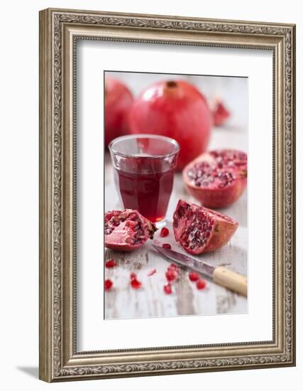 Whole and Sliced Pomegranates, Knives, Glass with Pomegranate Juice-Jana Ihle-Framed Photographic Print