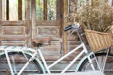 Bicycle with a Basket of a Dried Bouquet Flower Stand in Front of Wooden and Rustic House Backgroun-WichitS-Laminated Photographic Print