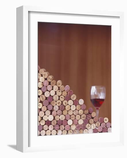 Wine Corks, Piled Up, and a Glass of Red Wine-Henrik Freek-Framed Photographic Print