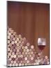 Wine Corks, Piled Up, and a Glass of Red Wine-Henrik Freek-Mounted Photographic Print