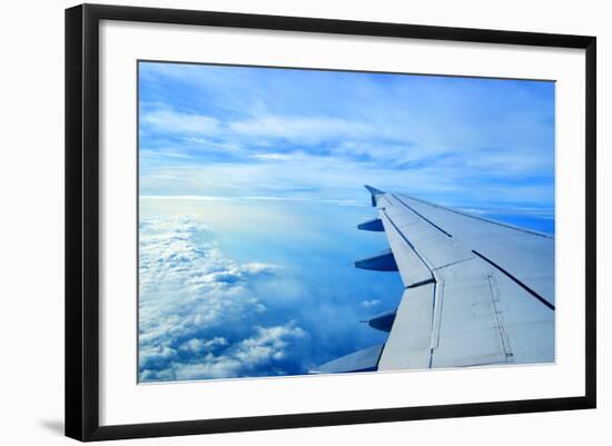 Wing of an Airplane Flying Above the Clouds-ghoststone-Framed Photographic Print