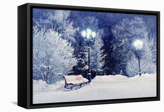 Winter Night Landscape Scene of Snow Covered Bench among Snowy Trees and Shining Lights during Snow-Marina Zezelina-Framed Premier Image Canvas