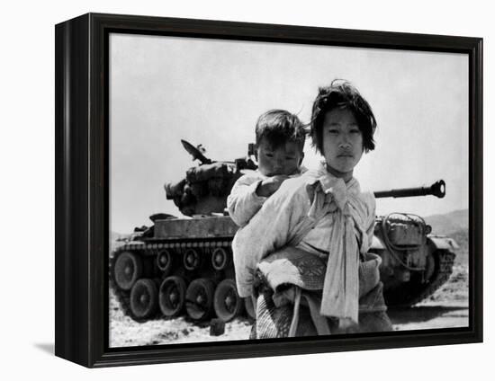 With Her Brother on Her Back, a War Weary Korean Girl Tiredly Trudges by a Stalled M-26 Tank-null-Framed Stretched Canvas