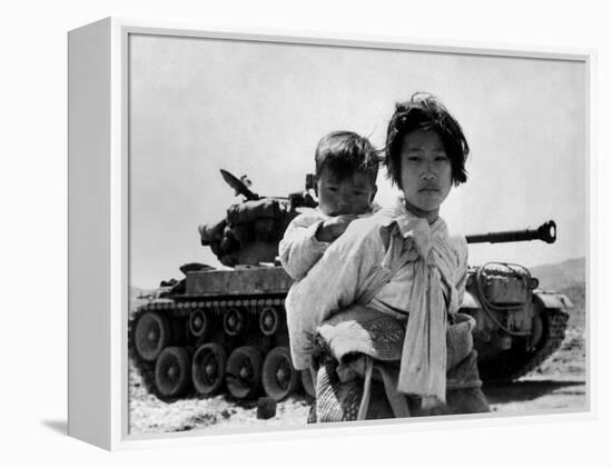 With Her Brother on Her Back, a War Weary Korean Girl Tiredly Trudges by a Stalled M-26 Tank-null-Framed Stretched Canvas