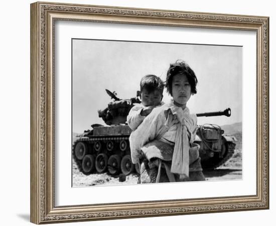With Her Brother on Her Back, a War Weary Korean Girl Tiredly Trudges by a Stalled M-26 Tank-null-Framed Photo