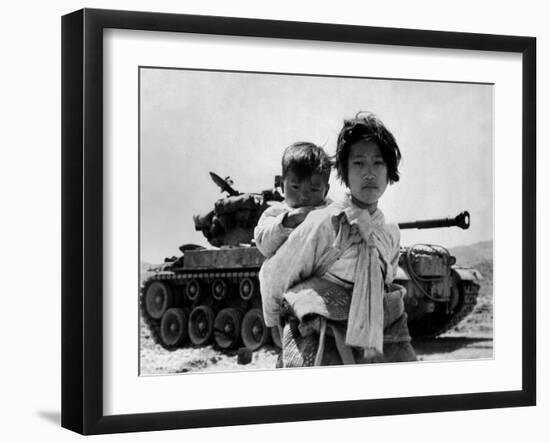 With Her Brother on Her Back, a War Weary Korean Girl Tiredly Trudges by a Stalled M-26 Tank-null-Framed Photo