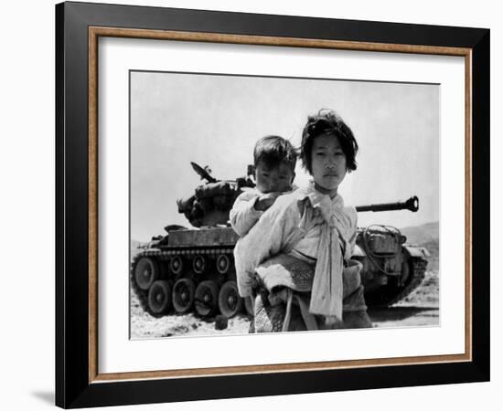 With Her Brother on Her Back, a War Weary Korean Girl Tiredly Trudges by a Stalled M-26 Tank-null-Framed Photo