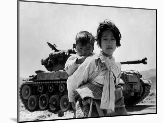 With Her Brother on Her Back, a War Weary Korean Girl Tiredly Trudges by a Stalled M-26 Tank-null-Mounted Photo