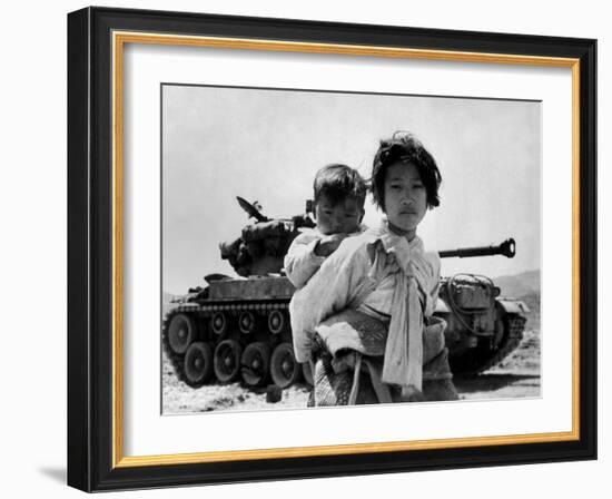 With Her Brother on Her Back, a War Weary Korean Girl Tiredly Trudges by a Stalled M-26 Tank-null-Framed Photo