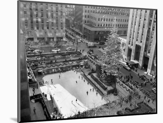 With the Famed Rockefeller Center Christmas Tree Rising Above Them, Skaters Glide on the Ice-null-Mounted Photographic Print