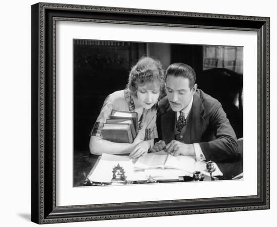 Woman and Man Sitting Together and Looking at a Book-null-Framed Photo