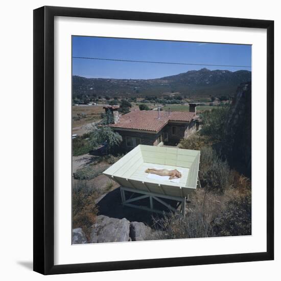 Woman as She Sunbathes Nude in on a Platform with Sides That Allow Privacy, Tecate, Mexico, 1961-Allan Grant-Framed Photographic Print