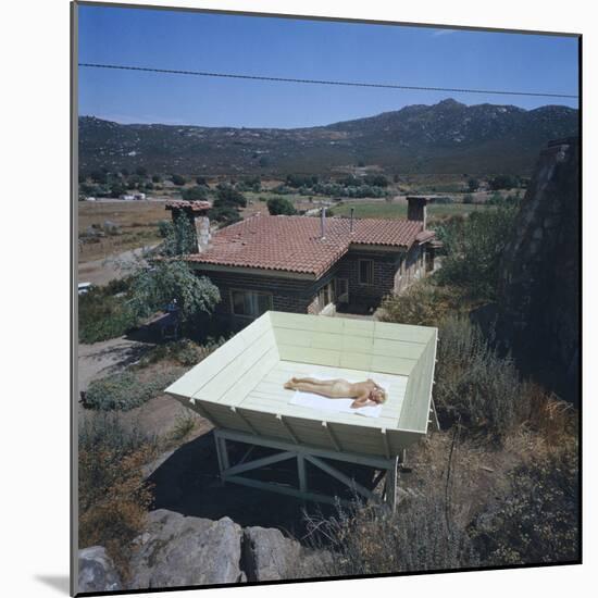Woman as She Sunbathes Nude in on a Platform with Sides That Allow Privacy, Tecate, Mexico, 1961-Allan Grant-Mounted Photographic Print