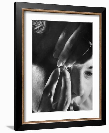 Woman Cautiously Placing a Contact Lens in Her Eye-Al Fenn-Framed Photographic Print