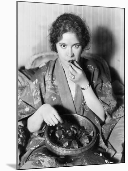 Woman Eating Chocolates Out of a Bowl-null-Mounted Photo