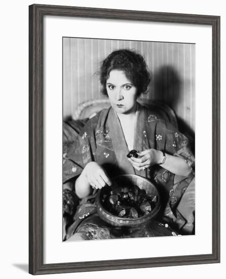 Woman Eating Chocolates Out of a Bowl-null-Framed Photo